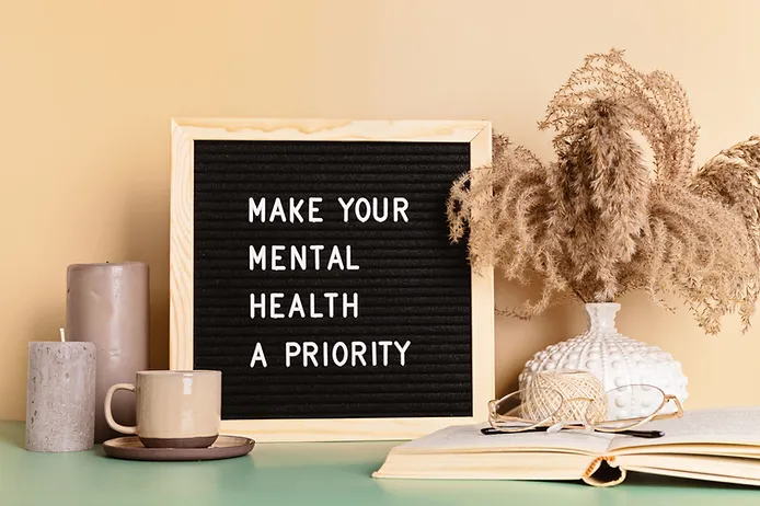 Sign reading 'Make Your Mental Health a Priority' on a table, emphasizing the importance of mental health care.