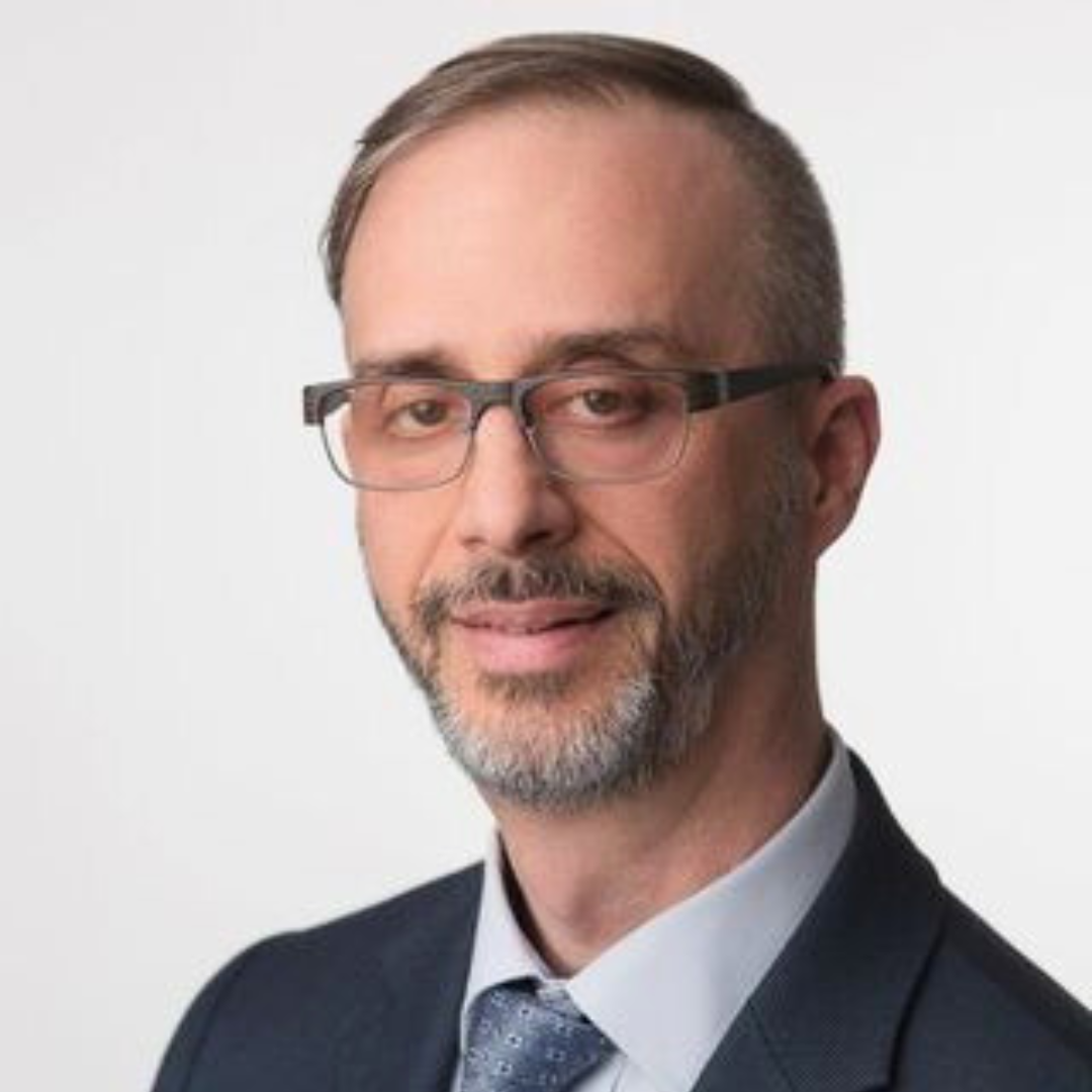 Professional headshot of a male psychiatrist with glasses and a beard in a suit.