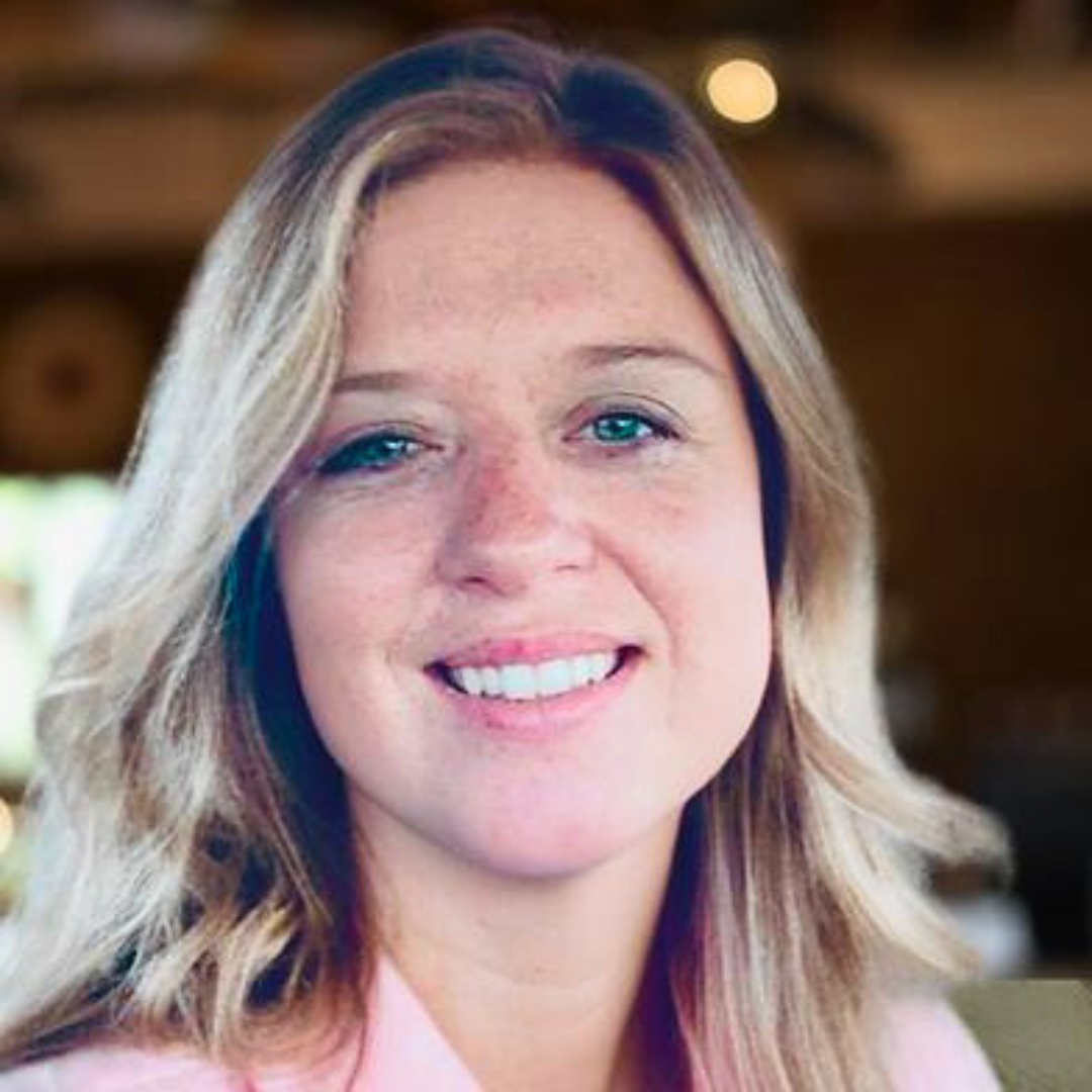 Smiling female therapist with blonde hair in a warm indoor setting.