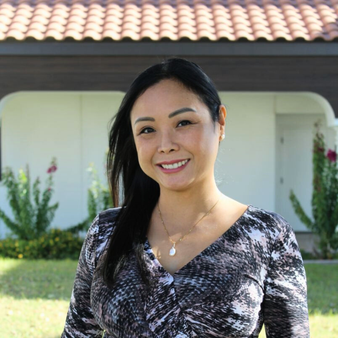 Smiling female therapist standing outdoors in front of a clinic