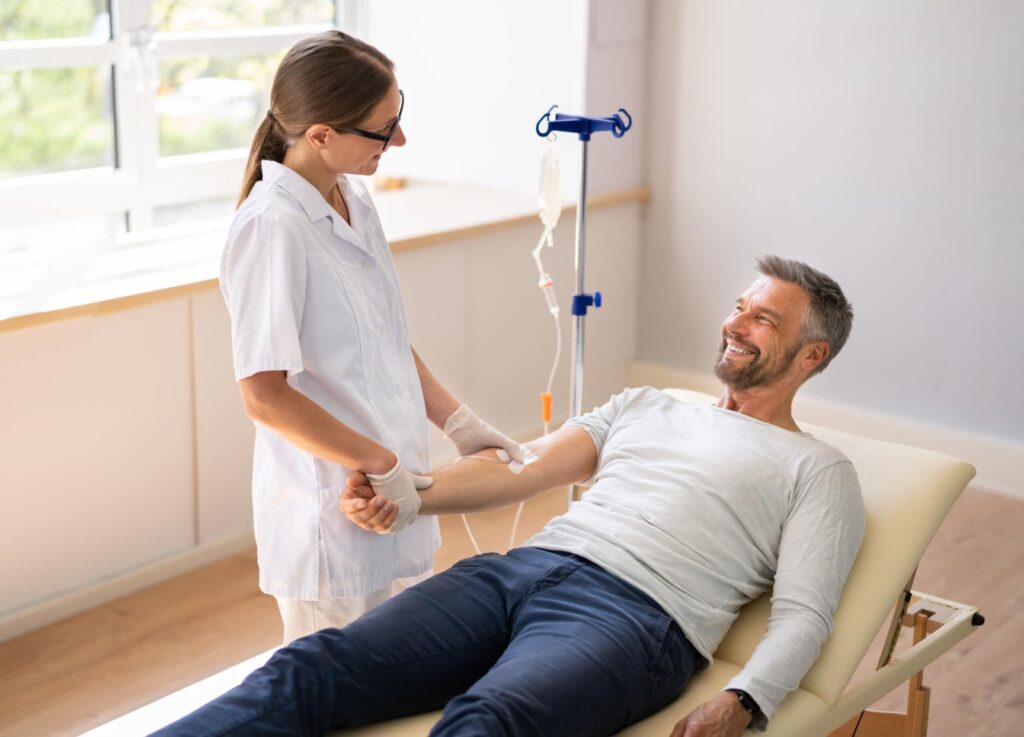 A nurse injects Ketamine Depression Treatment to a man seated in a medical setting, ensuring a safe and sterile procedure.