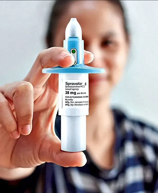 A woman holds a small medicine bottle of Spravato Esketamine Nasal Spray, showcasing its importance in health and wellness.