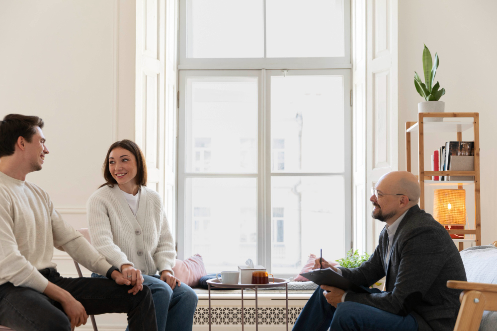 A man and woman converse with another couple in a cozy living room setting