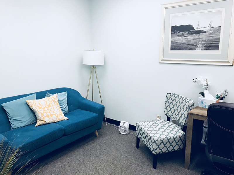 A small office featuring a blue couch and chair, designed for comfort and productivity in a limited area